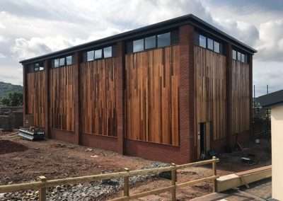 New building exterior at Talocher School, Monmouth, featuring brick and wood cladding.