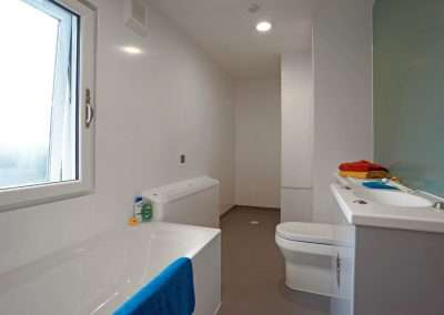 Modern accessible bathroom at Pinetree Court Hospital with bathtub and toilet