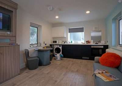 The Lodge at Pinetree Court Hospital: a modern studio apartment with kitchen, living area, and dining nook.