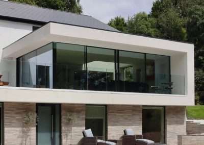 Modern cottage extension with large glass windows overlooking a garden