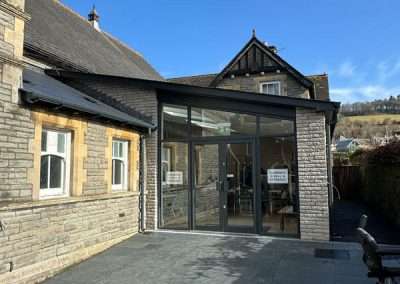 Clarence Hall entrance with modern glass extension and stone facade.
