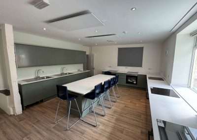Modern communal kitchen at Queenswood with a large island and sleek cabinetry.