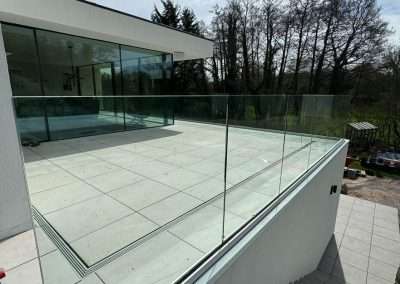 Modern home with glass balcony overlooking trees
