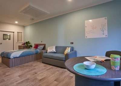 Juniper Studio: A cozy room with a bed, sofa, and table.