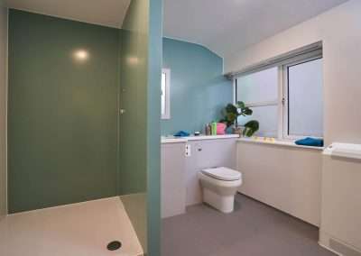 Accessible bathroom with shower, toilet, and sink in a Juniper Studio.